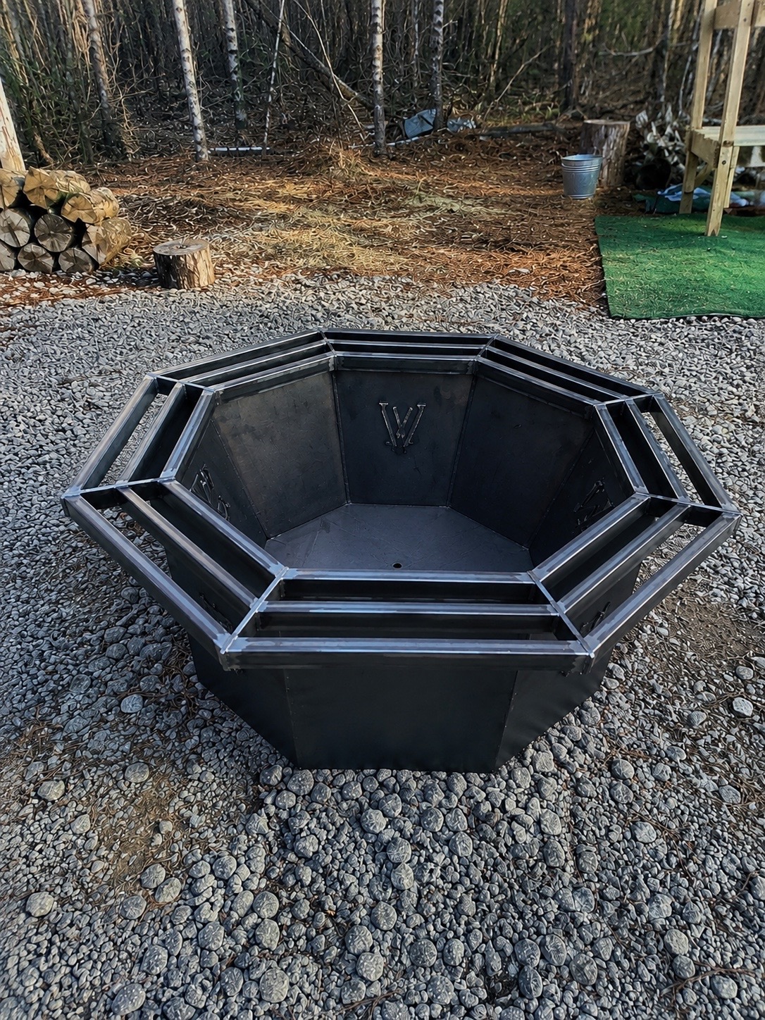 Raw steel octagon fire pit with double surround ring fabricated by Valor Outdoor Design & Build